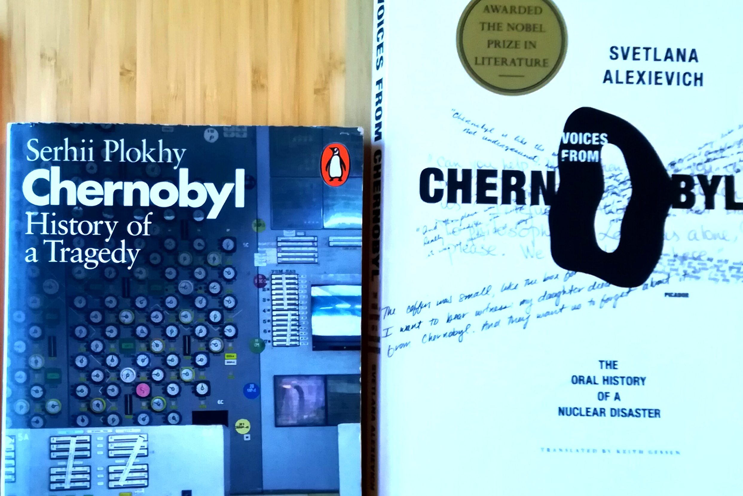 Two books about Chernobyl on a table, face up. 'Chernobyl: History of a Tragedy' by Serhii Plokhy and 'Voices from Chernobyl: the oral history of a nuclear disaster' by Svetlana Alexievich (a sticker on the cover reads 'awarded the Nobel prize in literature').